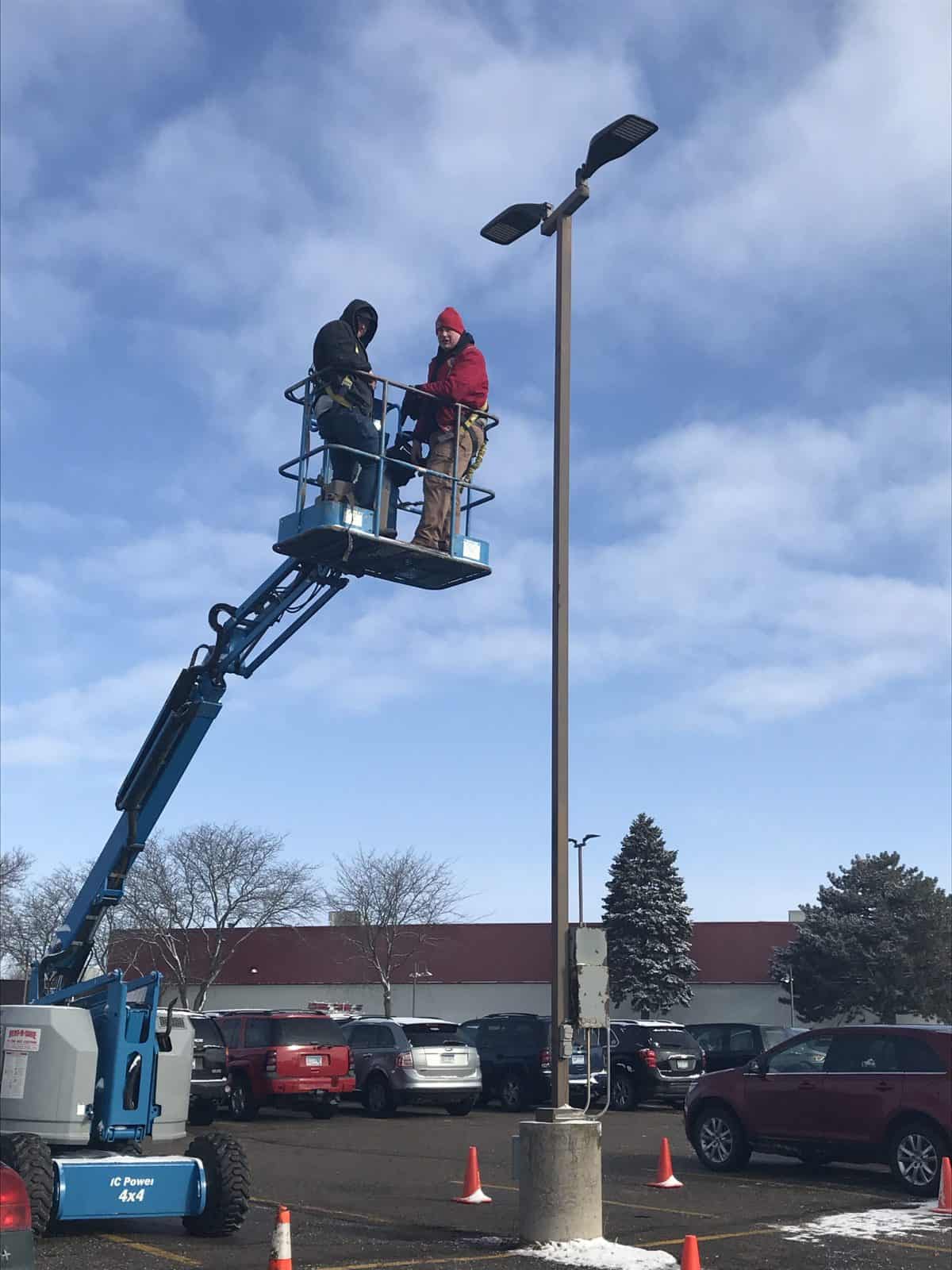 Exterior lighting installation during winter months, electricians on lift, Retrofit Lighting and Design